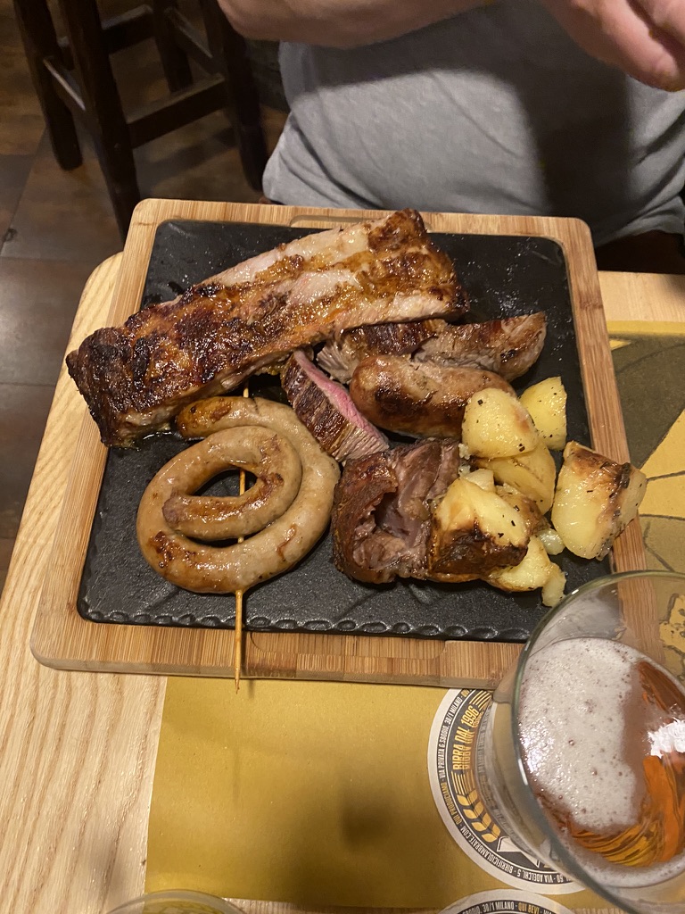 Grillilihaa, makkaraa ja perunoita paikallisen oluen kanssa
